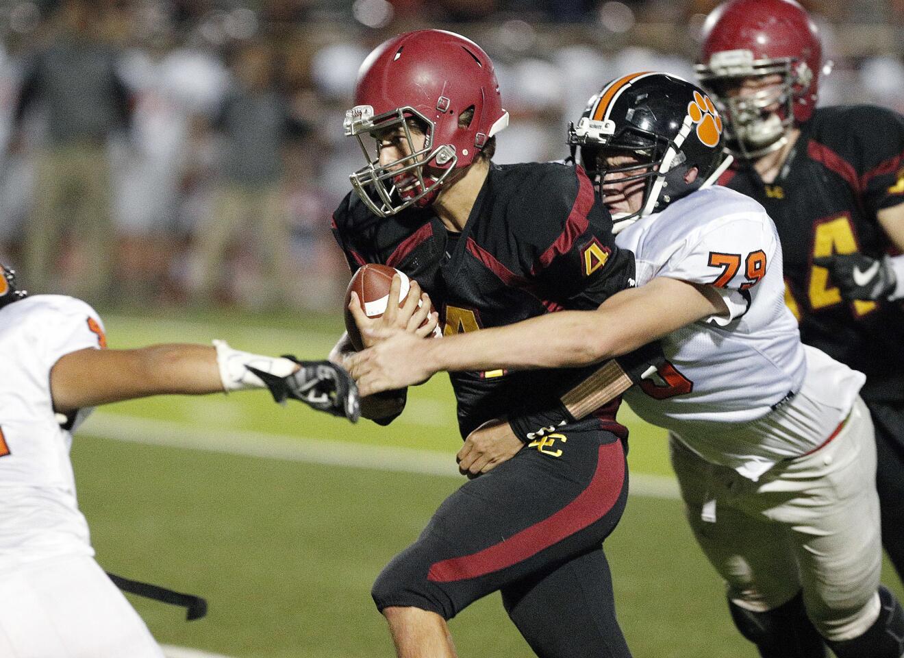 La Canada's quarterback Matt Bromley carries the ball on a quarterback sneak with South Pasadena's Jove Yates wrapping his arms around him in a Rio Hondo League football game at La Canada High School on Friday, October 19, 2018. It was the homecoming football game.