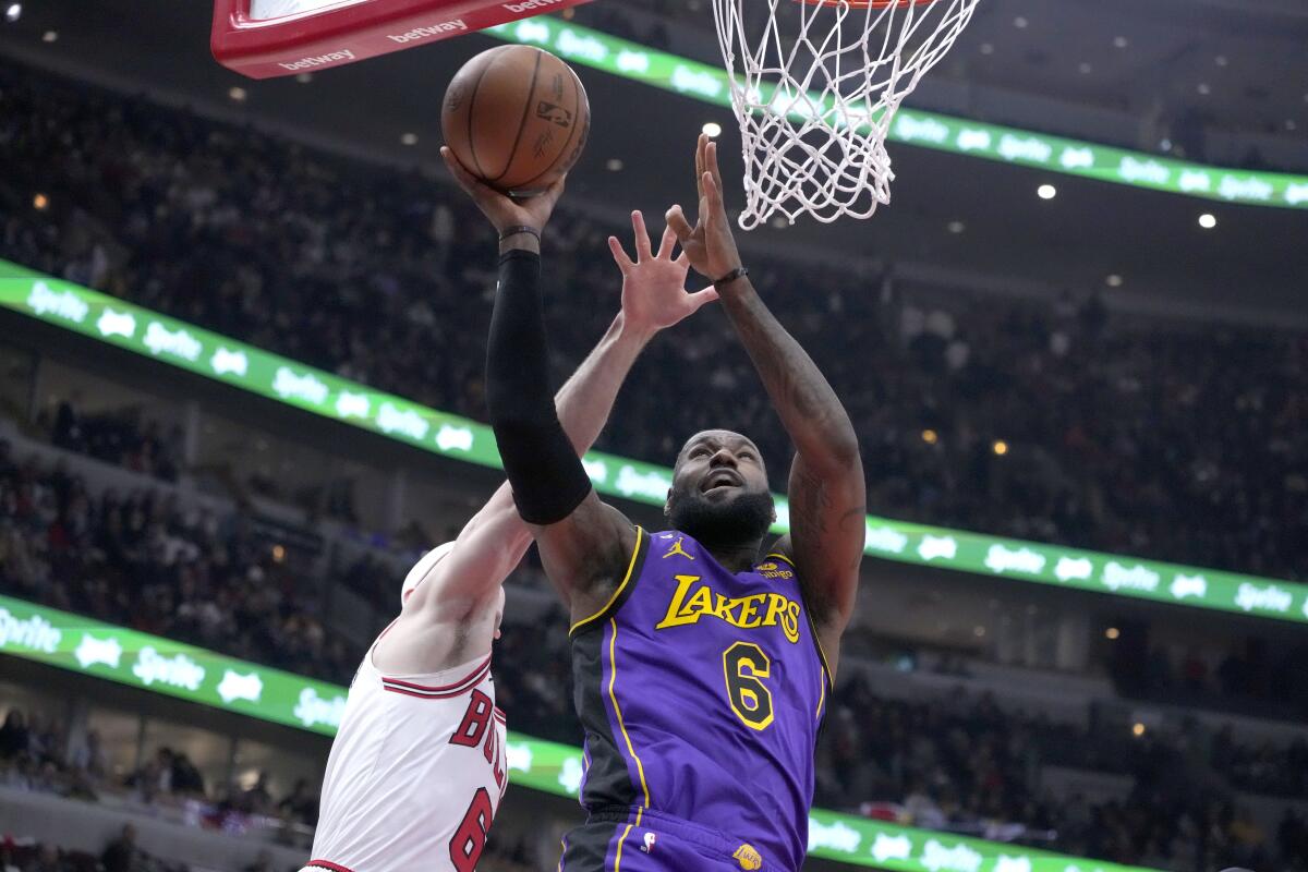 Lakers' LeBron James drives to the basket as Chicago Bulls' Alex Caruso defends.