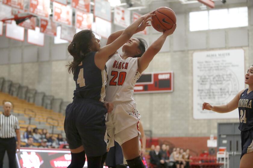 Huntington Beach High's Marisa Tanga (20) is fouled by Sonora's Luz Lizardo (4) during the first half in the Matt Denning Nike Hoops Classic at Mater Dei High on Saturday, January 5, 2019.