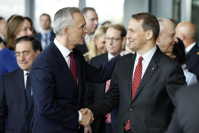 NATO Secretary General Jens Stoltenberg, left, shakes hands with Poland's Foreign Minister Radoslaw Sikorski a ceremony to mark the 75th anniversary of NATO at NATO headquarters in Brussels, Thursday, April 4, 2024. NATO marked on Thursday 75 years of collective defense across Europe and North America, with its top diplomats vowing to stay the course in Ukraine as better armed Russian troops assert control on the battlefield. (AP Photo/Geert Vanden Wijngaert)