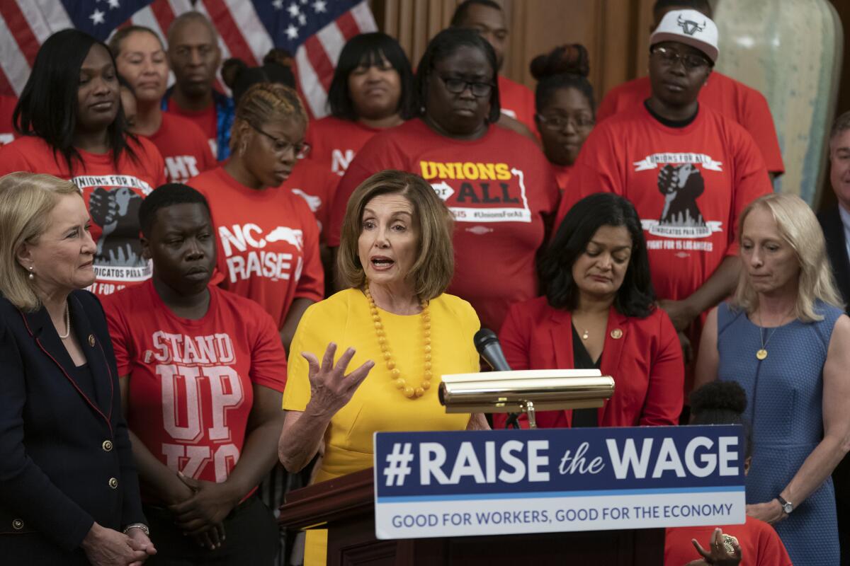 La presidenta de la Cámara de Representantes Nancy Pelosi, acompañada de otros demócratas y activistas que promueven sueldos más altos después de que la cámara baja aprobó un proyecto para incrementar el salario mínimo federal por primera vez en una década, a 15 dólares la hora. (AP Foto/J. Scott Applewhite)