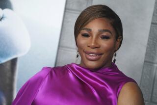 Serena Williams smiles while wearing a luxe purple garment