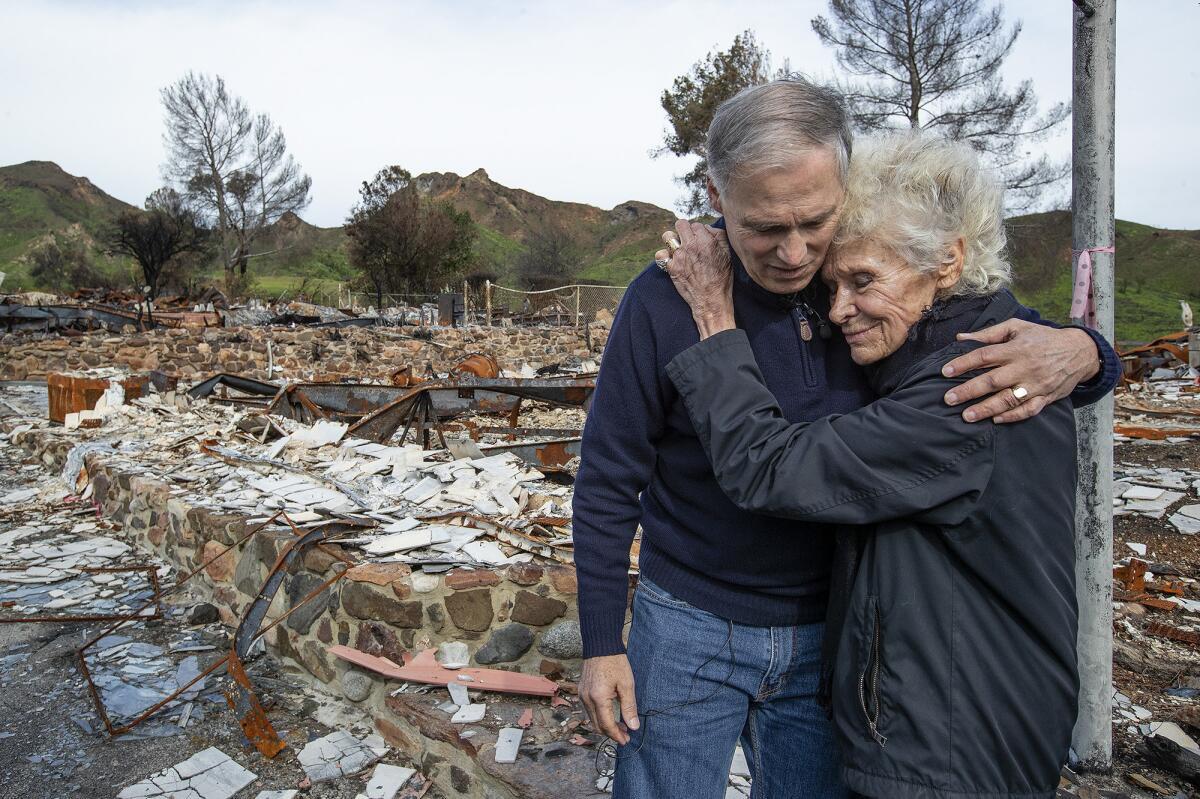 Inslee embraces Marsha Maus, 75, whose home was destroyed in the Woolsey fire.