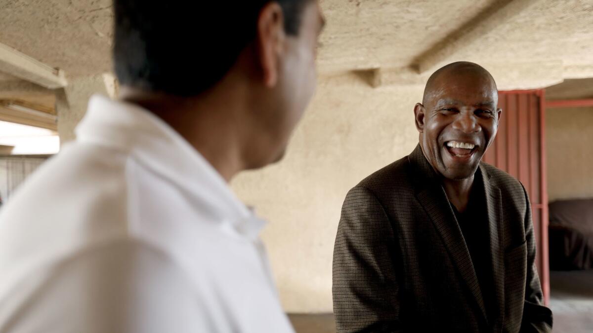 The Rev. Richard Reed, right, talks with Joe Patel, who owns the motel building that Reed's nonprofit leases for homeless housing.