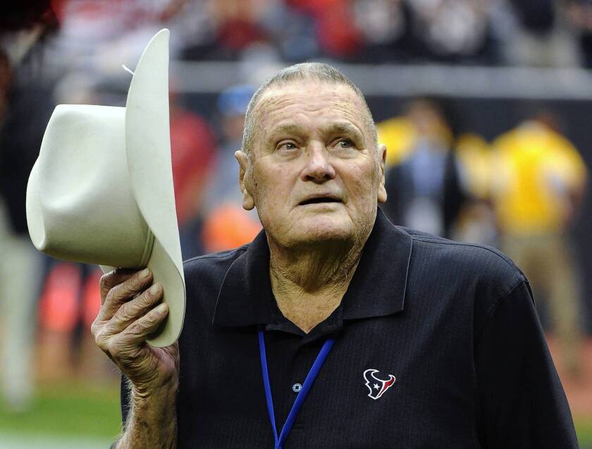 In this Jan. 7, 2012, photograph, former Houston Oilers coach Bum Phillips tips his hat to the crowd before an NFL playoff football game in Houston. Phillips died Friday at the age of 90.