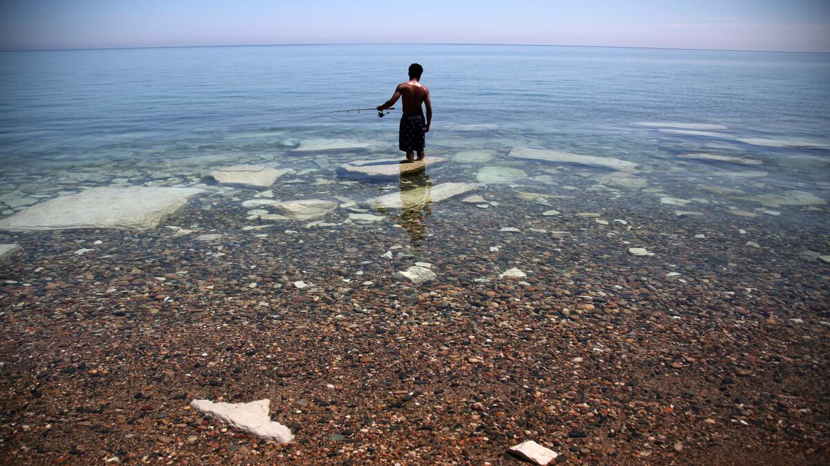 Terrance Young fishes at Illinois Breach State Park, where the Lake Michigan shoreline has been hit hard by erosion.