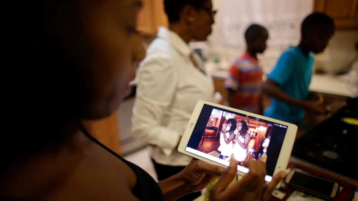 Trisha Michael scrolls through photos on an electronic tablet showing her twin sister, Kisha. (Robert Gauthier / Los Angeles Time)