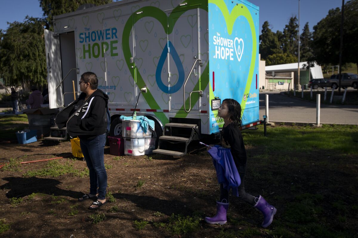 After showering Rita Rios, 25, left, and her daughter Shailene Rios, 8, stand outside in Lincoln Park. Orders to close most businesses and public restrooms to slow the spread of the coronavirus have made it more difficult for homeless people to find places to keep clean.