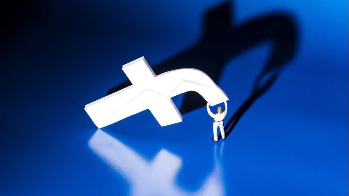 A figure carrying the logo of social network Facebook is viewed in Paris.