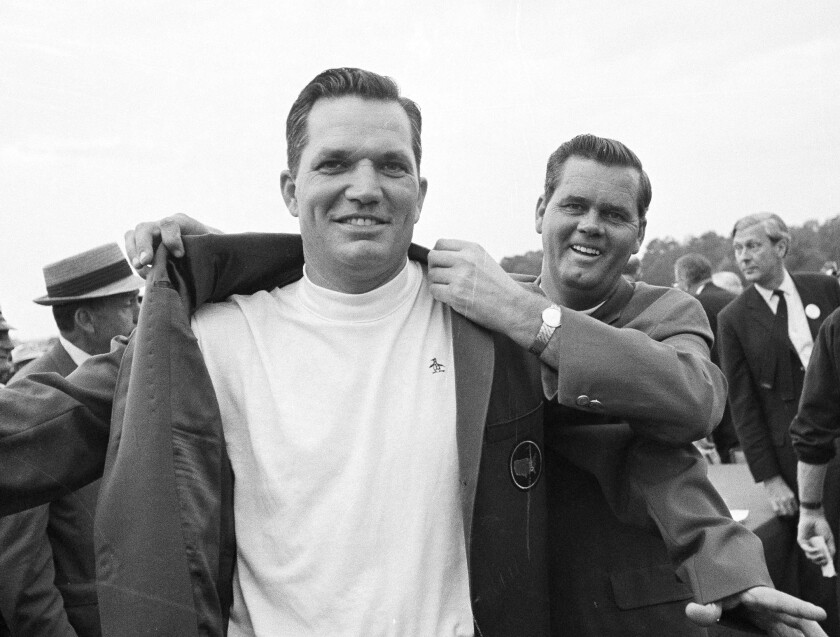 FILE -B ob Goalby gets the traditional green jacket as champion of the Masters golf tournament in Augusta, Ga., April 14, 1968, from the previous year's winner, Gay Brewer. Goalby was declared champion although he finished in a 277 tie with Roberto de Vicenzo of Argentina. De Vicenzo was pushed back to second after an error was discovered in his scorecard. Goalby has died. His death Wednesday, Jan. 19, 2022, in his hometown of Belleville, Ill., was confirmed by the PGA Tour and Bill Haas, his great nephew. Goalby was 92. (AP Photo, File)