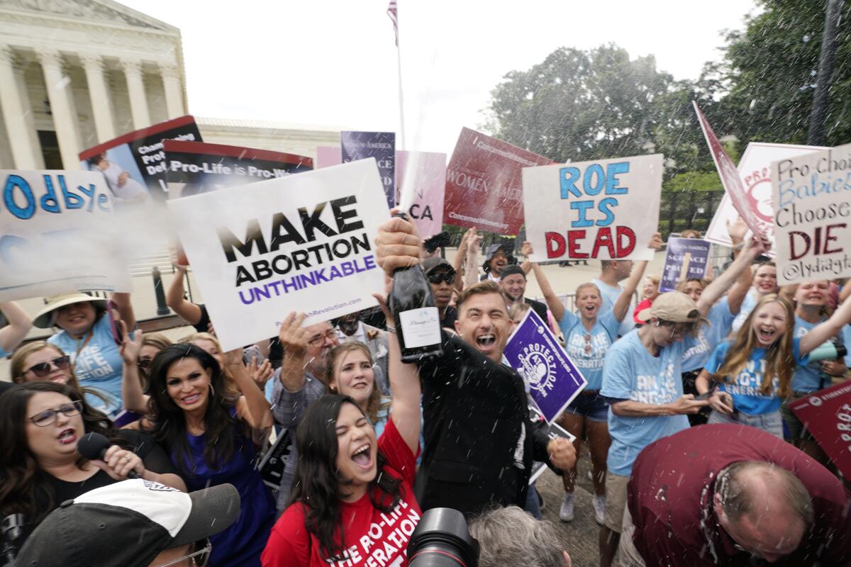 Celebrants hold signs including, "Make abortion unthinkable."