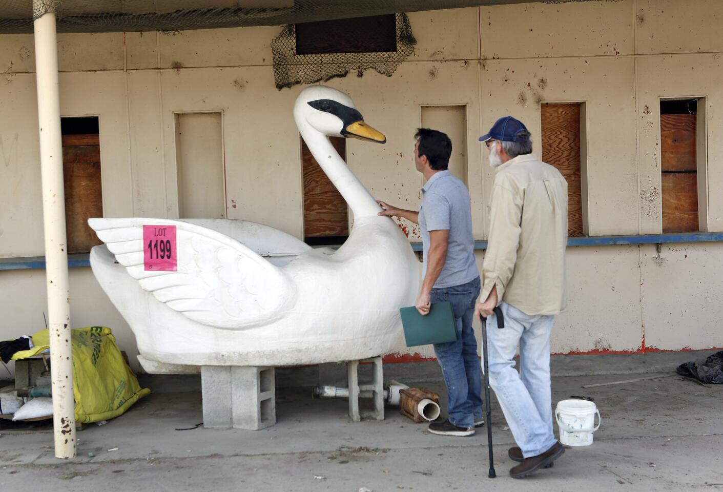 Sergio Santino, left, of San Marino and friend Jerry Rosenfeld of Pasadena inspect a 7-foot-high swan boat in the infield at Hollywood Park.