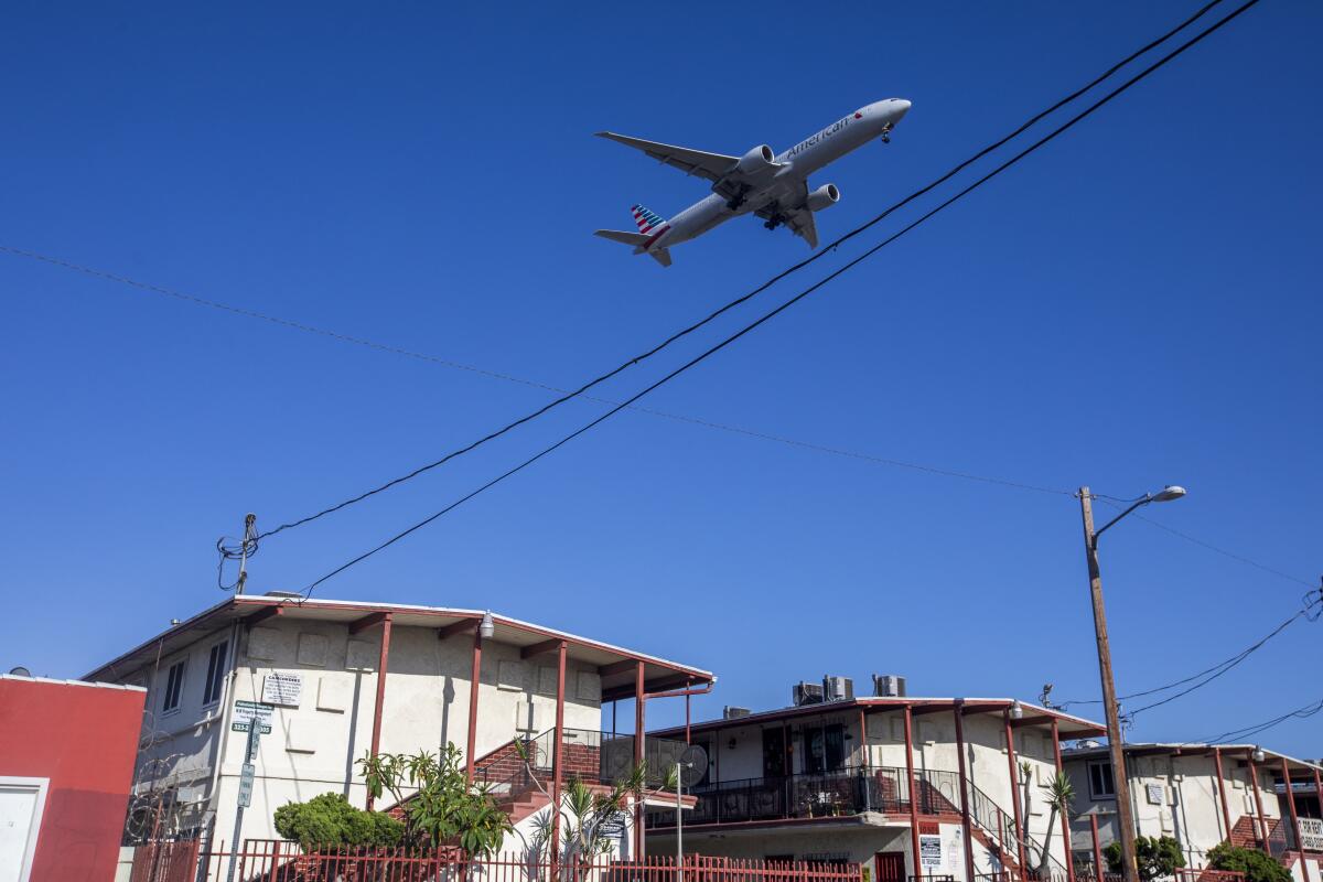A plane flies over a residential neighborhood