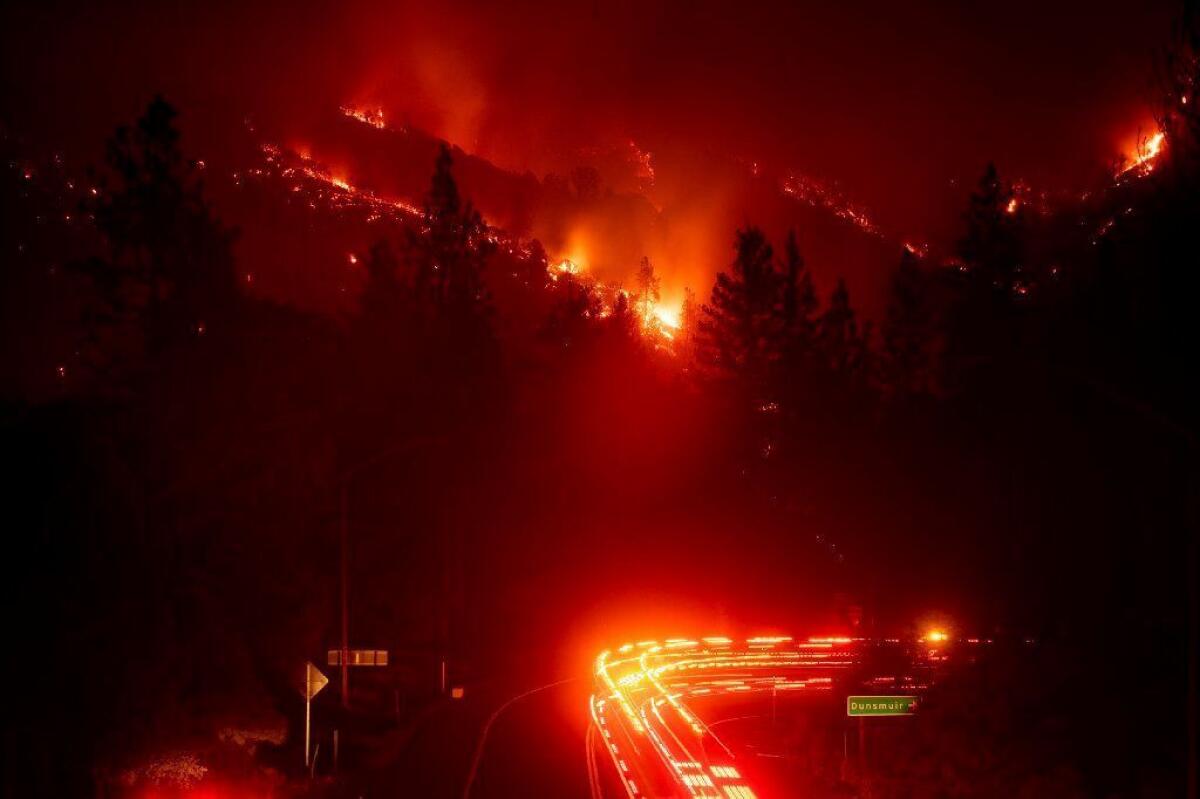 Firetrucks pass the Delta fire burning in the Shasta-Trinity National Forest on Wednesday. Parked trucks lined more than two miles of Interstate 5 as both directions remained closed to traffic.