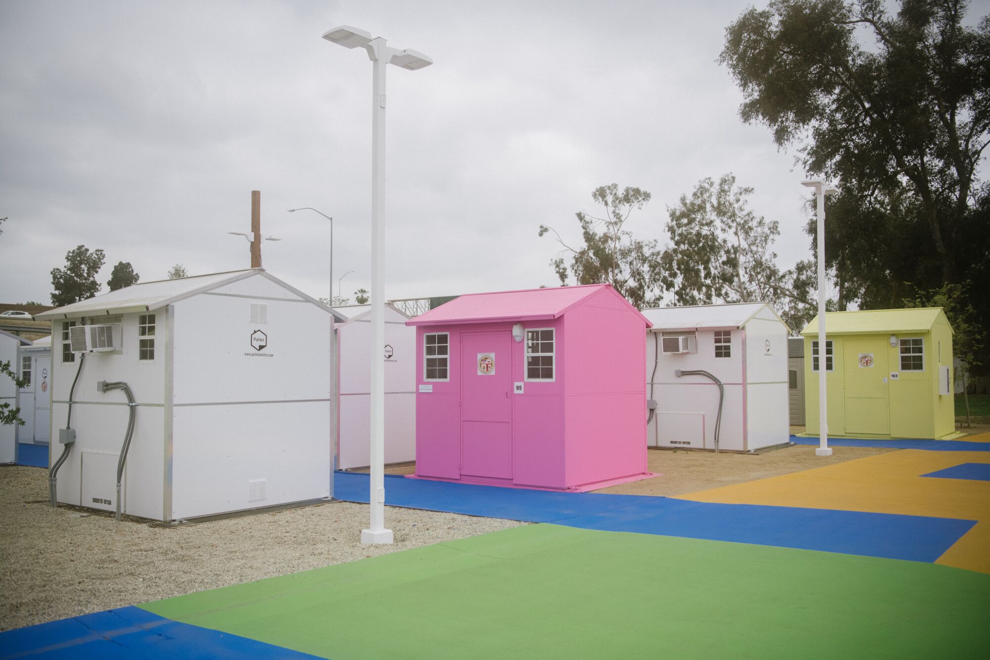 A group of pink, white and yellow tiny homes.