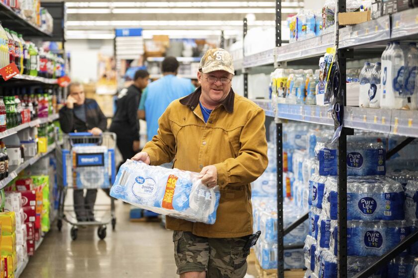 John Beezley, of Bonham, buys cases of water after learning that a boil water notice was issued for the entire city of Houston on Sunday, Nov. 27, 2022, at Walmart on S. Post Oak Road in Houston. Beezley just arrived in town with his wife, who is undergoing treatment starting tomorrow at M.D. Anderson Cancer Center, where they are staying in a camping trailer. They turned on the television after settling in and saw that a boil water notice had been issued. Beezley decided to go out immediately fearing that by tomorrow people would be buying up all of the available water. (Mark Mulligan/Houston Chronicle via AP)