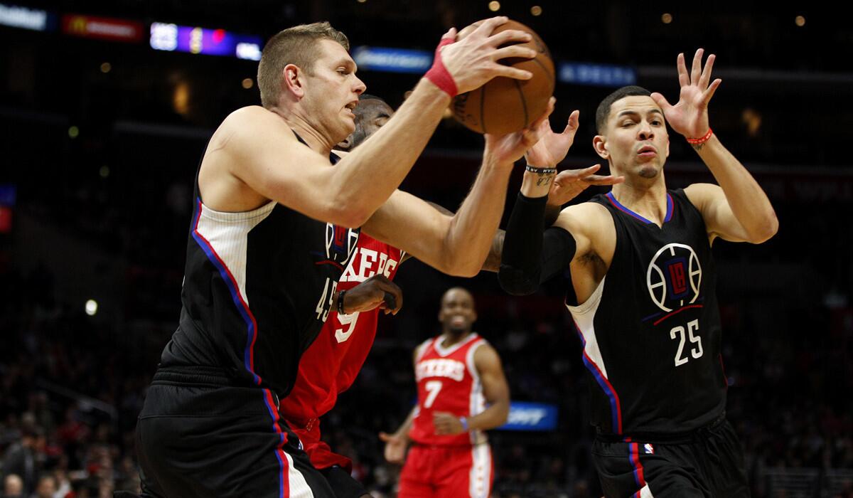Los Angeles Clippers center Cole Aldrich (45) grabs a defensive rebound from Philadelphia 76ers guard JaKarr Sampson (9) with teammate Clippers guard Austin Rivers (25) on the right in the second half at Staples Center Saturday night.