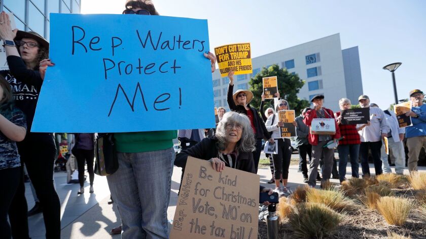 Activists rally outside of Rep. Mimi Walters' Irvine office in the hours before Tuesday's tax vote in Washington, D.C.