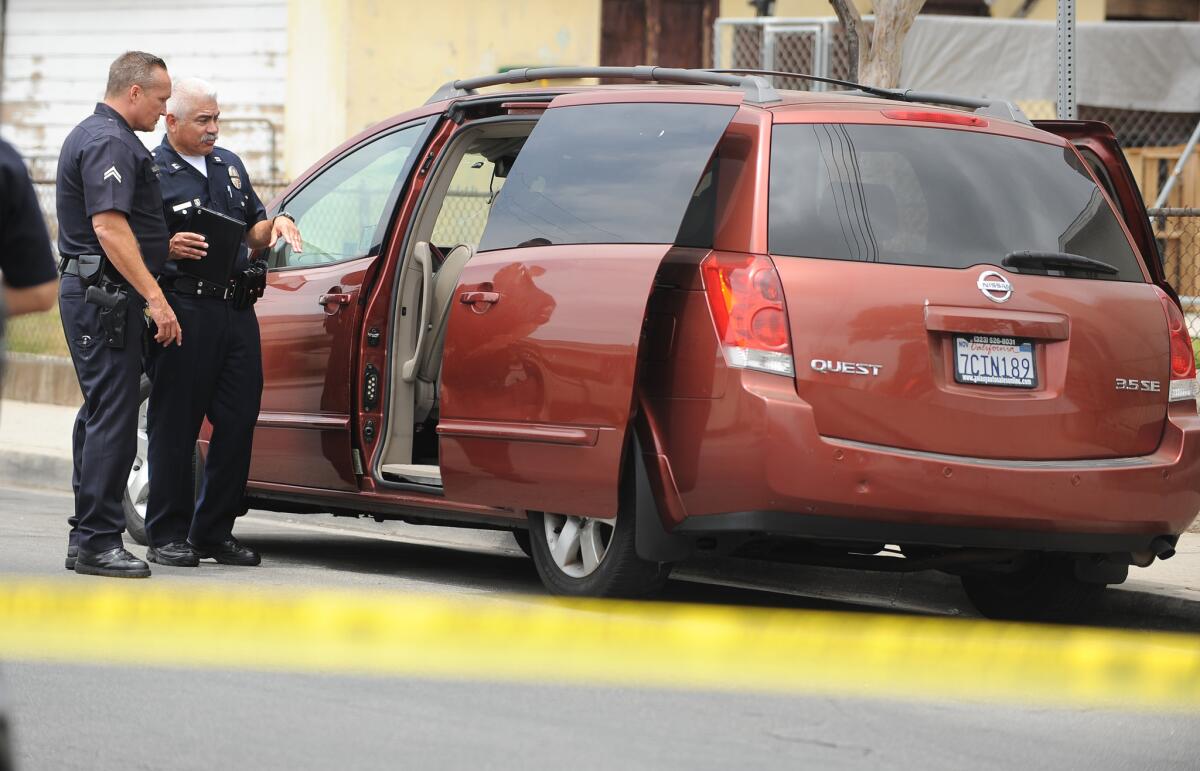 LAPD officers stand by the minivan found empty in East L.A. Authorities believe the van was stolen by a man suspected of kidnapping his 2-year-old son on May 23.