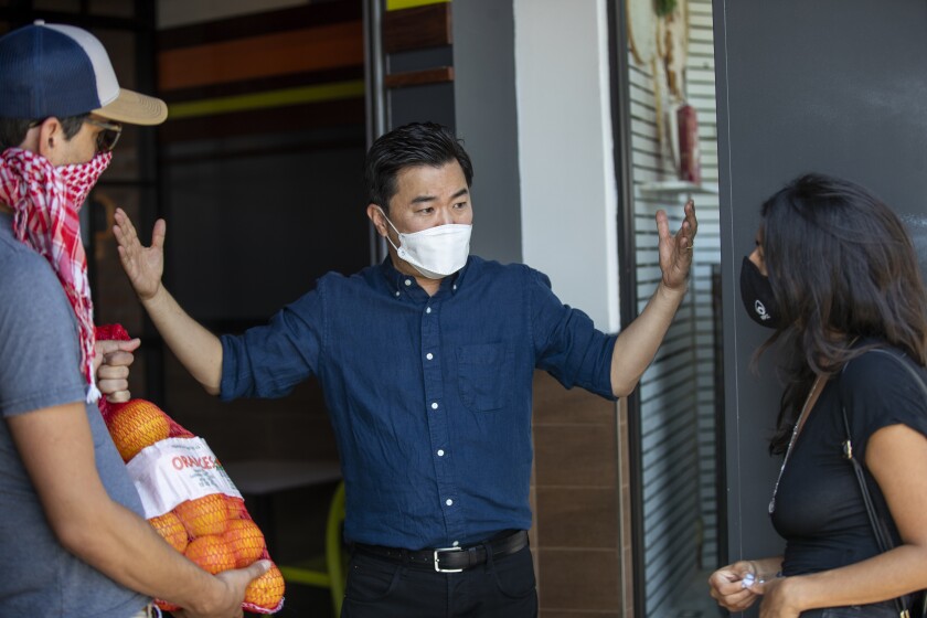 Los Angeles City Councilman David Ryu speaks to two people