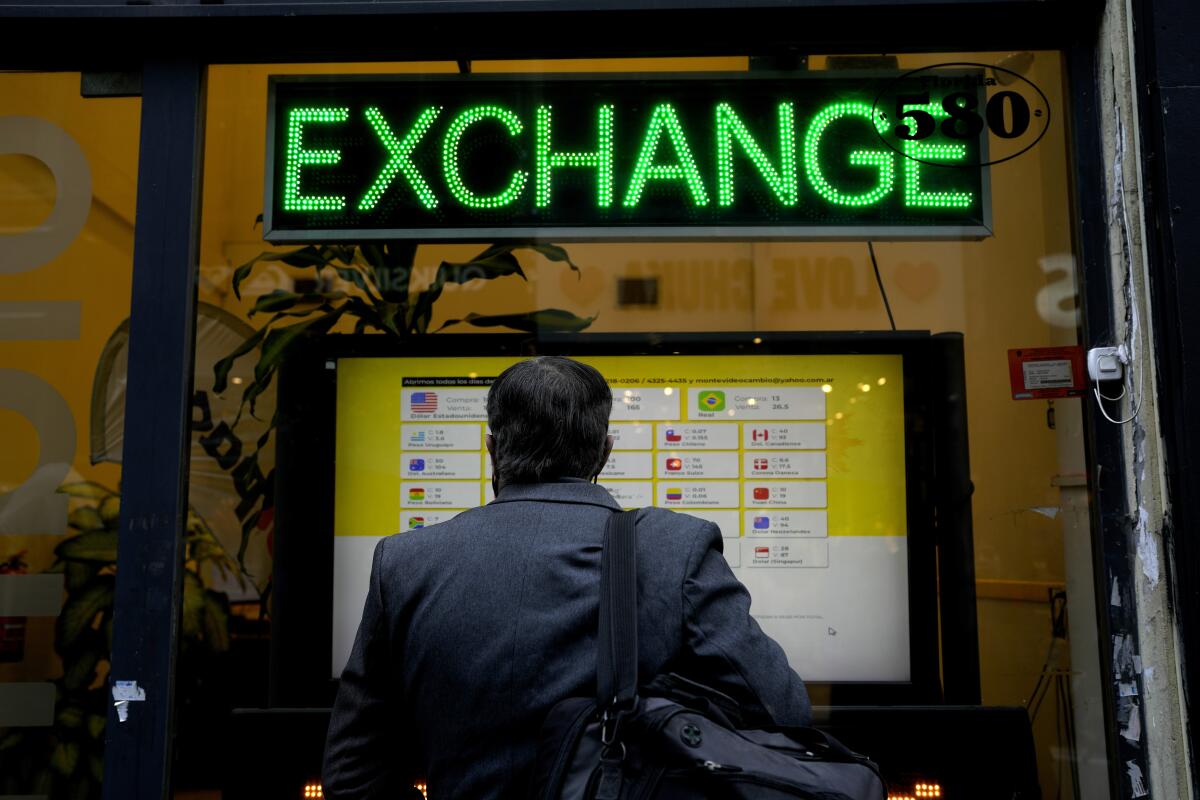 Un hombre revisa las tasas de compra y venta de divisas en una casa de cambio