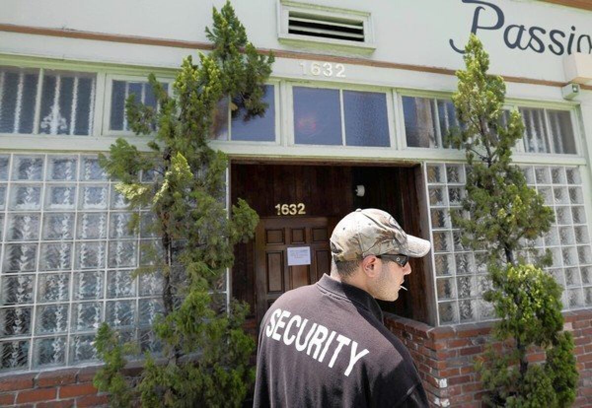 A security guard who declined to give his name stands outside House of Kush in 2010.
