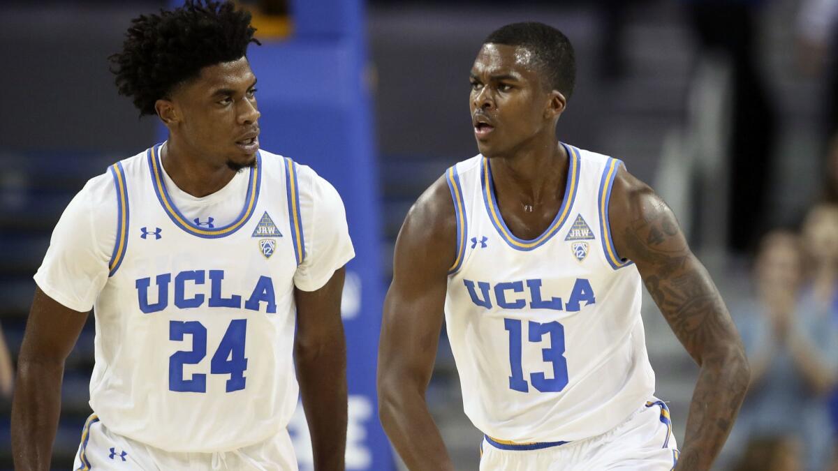 UCLA guard Kris Wilkes, right, celebrates after dunking the ball along with guard Jalen Hill, left, against IPFW during the first half on Nov. 6.