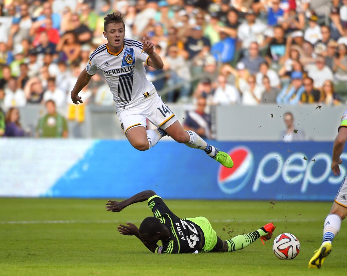 Galaxy midfielder Robbie Rogers jumps over Sounders FC midfielder Micheal Azira during the second half of an MLS playoff game on Nov. 23, 2014, in Carson, Calif.