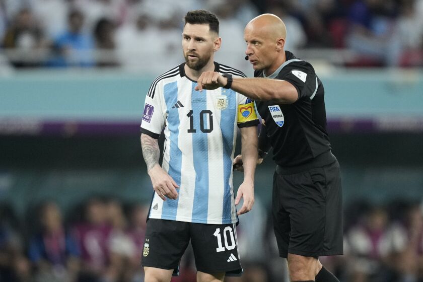 FILE - Referee Szymon Marciniak gestures as he speaks with Argentina's Lionel Messi during the World Cup round of 16 soccer match between Argentina and Australia at the Ahmad Bin Ali Stadium in Doha, Qatar, on Dec. 3, 2022. Polish soccer referee Szymon Marciniak has apologized for speaking at a business event tied to a far-right politician and was confirmed by UEFA to officiate next week's Champions League final. Marciniak’s appointment for the game between Manchester City and Inter Milan on June 10 was at risk. (AP Photo/Jorge Saenz, File)