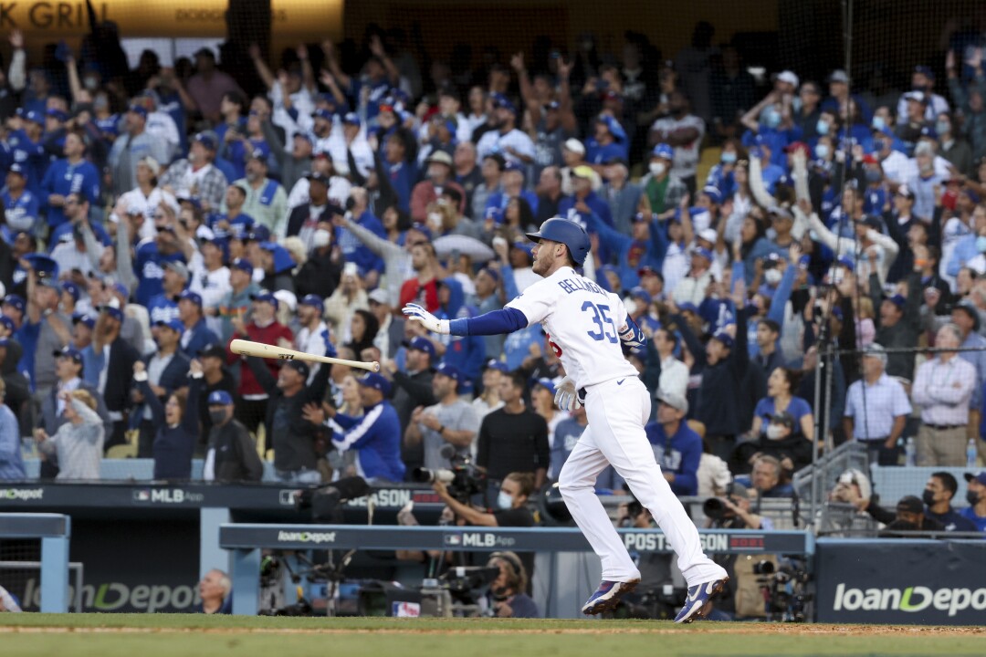 Cody Bellinger of the Los Angeles Dodgers throws the bat after a home run with three runs.