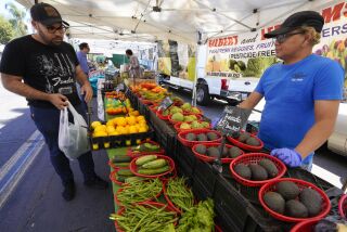 San Diego, CA - April 13: At the Farmers Market in Little Italy on Wednesday, April 13, 2022 in San Diego, CA., Sonny Sarzona from Gilbert and Lee Farms assisted Kareem Captain with selecting fresh vegetables. Gilbert and Lee Farms is one of the vendors that has plans to expand to Chula Vista’s Farmers Market. (Nelvin C. Cepeda / The San Diego Union-Tribune)