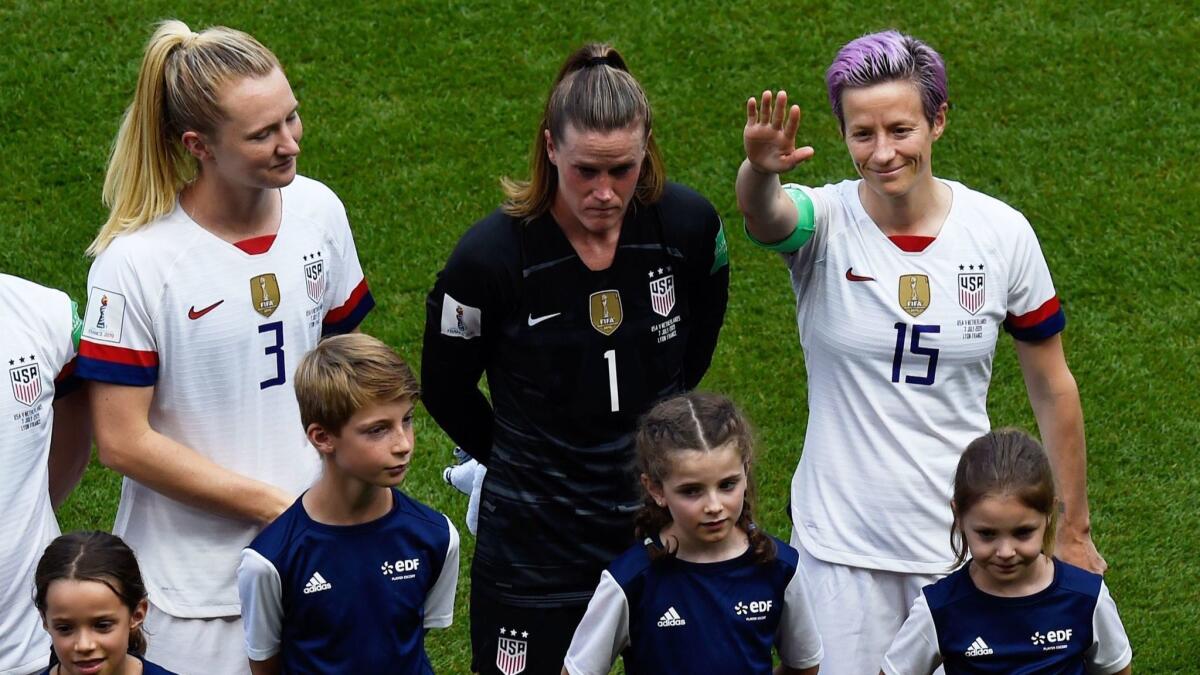 U.S. forward Megan Rapinoe waves while standing next to teammates Samantha Mewis, far left, and Alyssa Naeher before the start of the Women's World Cup final against the Netherlands in Lyon, France, on Sunday.