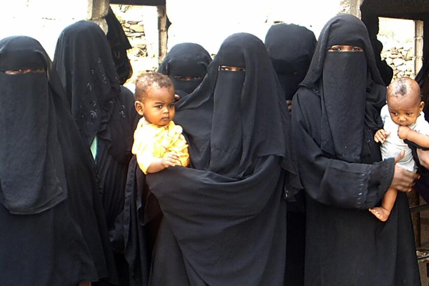 Women who are descendants of African slaves hold their children as they gather in the village of Aslam in northern Yemen on July 15, 2010. Many are still fighting against the stigma of their former status as "slaves" and have familiy members still living in bondage.