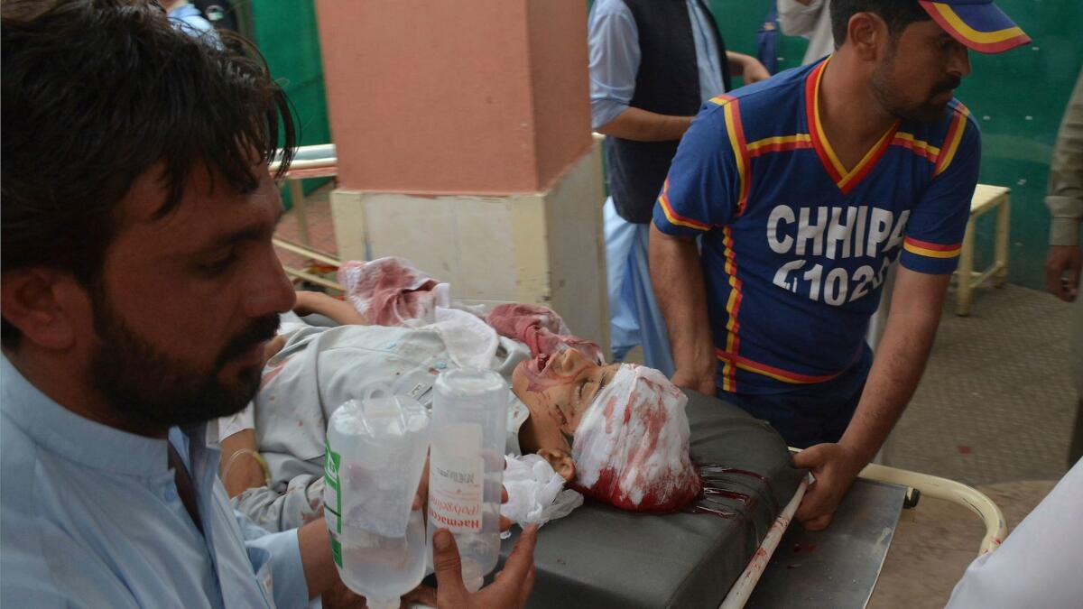 Volunteers rush an injured person to a hospital in Quetta, Pakistan, after an assassination attempt against a lawmaker killed 25 people and wounded more than 30 others.