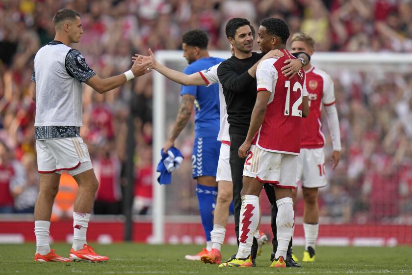 Arsenal's manager Mikel Arteta greets Arsenal's Jurrien Timber at the end of the English Premier League soccer match between Arsenal and Everton at the Emirates stadium in London, Sunday, May 19, 2024. Arsenal won the match 2-1 but it was not enough to clinch the Premier League title as Manchester City won their last match of the season the top the season ending standings. (AP Photo/Alastair Grant)