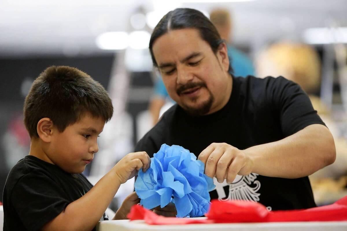 Dewey Tafoya teaches David Torres, 6, how to make paper flowers at Self Help Graphics in its new location in a renovated fish-processing plant in Boyle Heights.