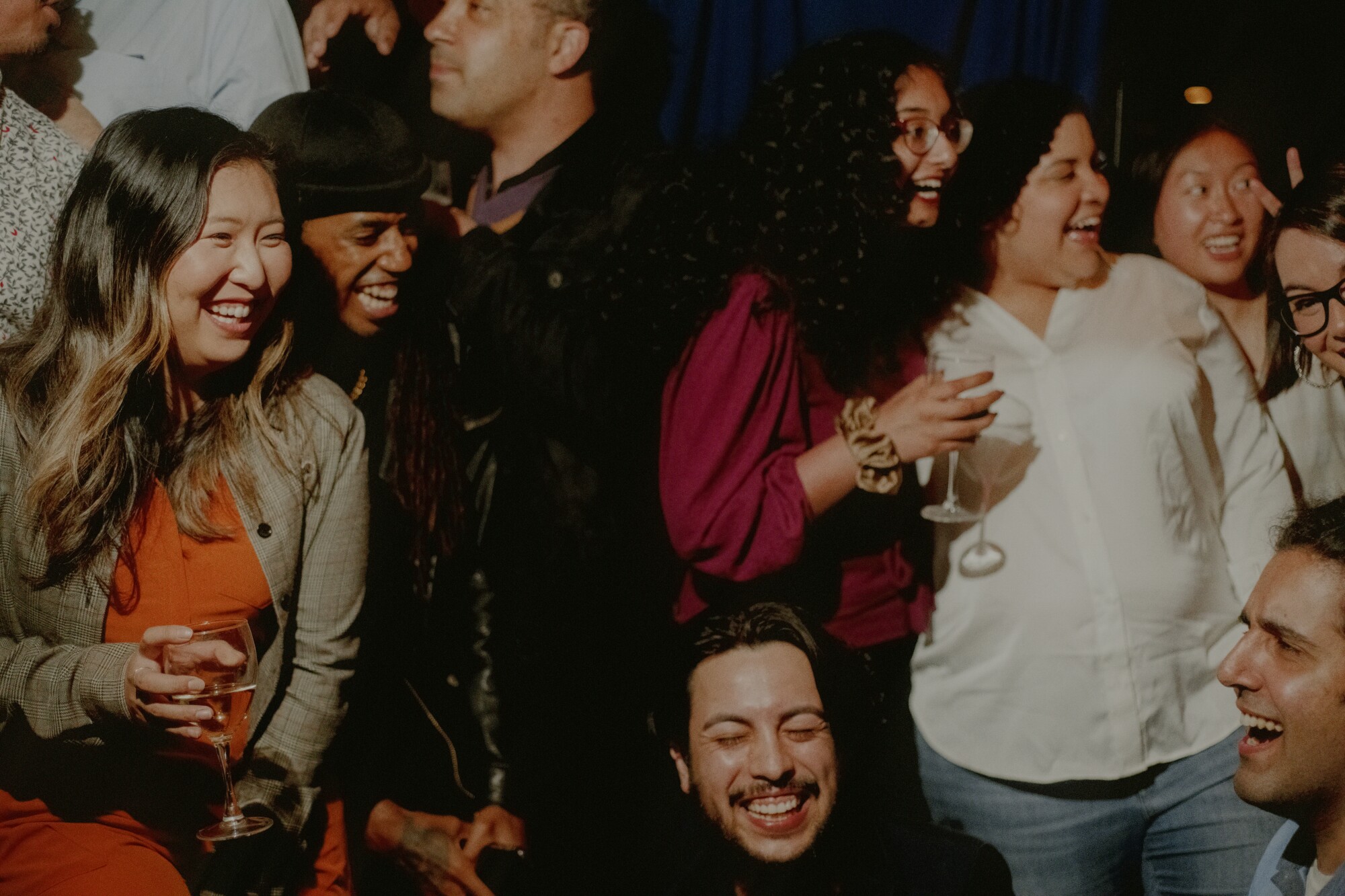 A group of people laughing and holding drinks.