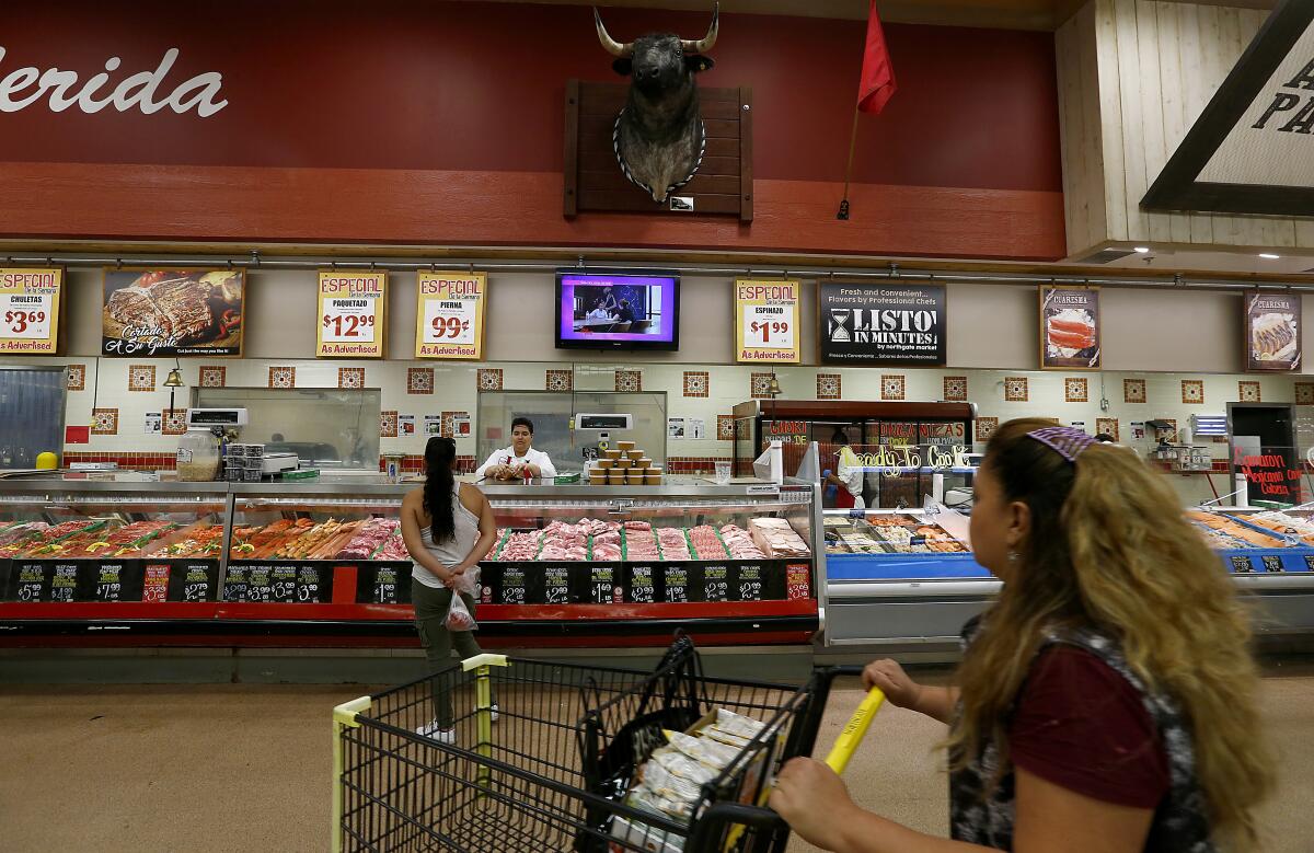 Customers browse the meat section at Northgate