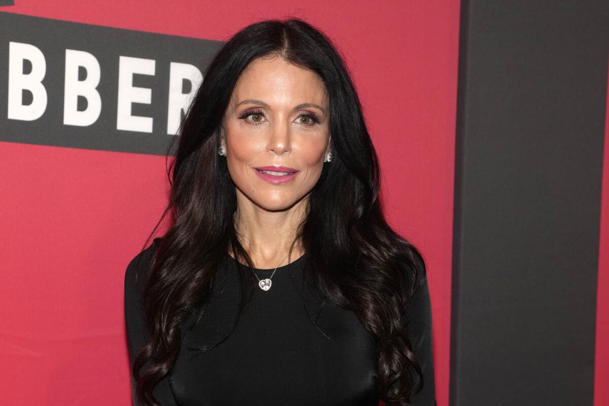 Bethenny Frankel wears a black long sleeve top as she poses for photos at a red carpet event