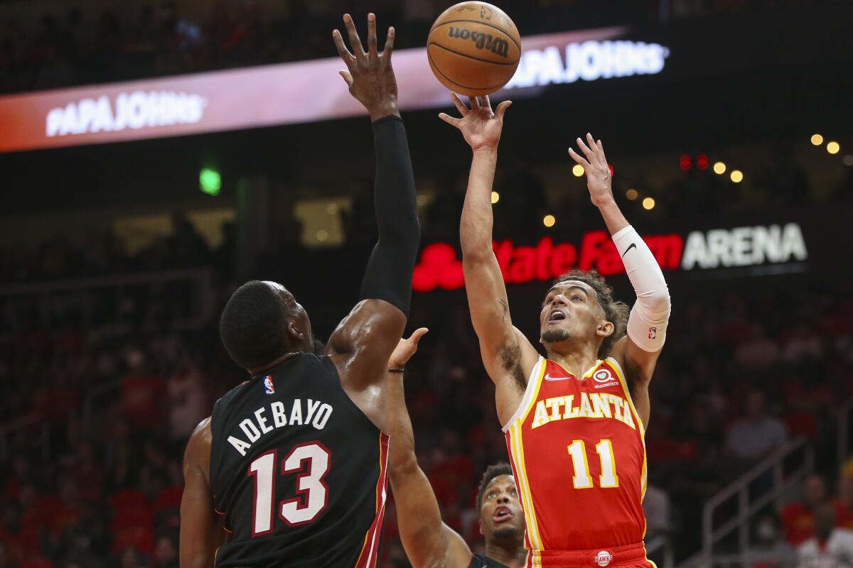 Hawks guard Trae Young (11) shoots over Heat center Bam Adebayo (13) during the first half April 22, 2022.
