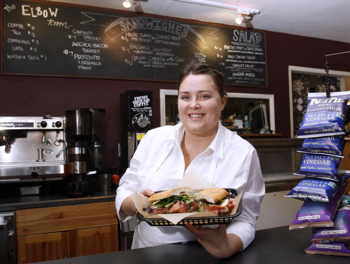 Thee Elbow Room owner Cristal Arguelles shows the hand-crafted prosciutto and arugula panini at the newly opened location at 2418 Honolulu Ave., Montrose, on Saturday, Feb. 8, 2014. Arguelles is applying for a liquor license so she can offer local California craft beer in addition to the sandwiches and coffee now available.