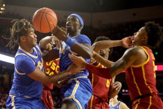 UCLA's Adem Bona, center, loses control of a ball during the Bruins' 65-50 win over USC at Galen Center.