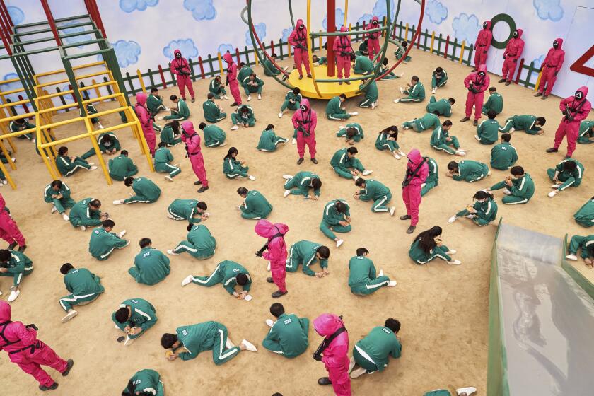 This undated photo released by Netflix shows a scene of contestants vying to win the Dalgona Korean candy challenge in a scene from "Squid Game." Squid Game, a globally popular South Korea-produced Netflix show that depicts hundreds of financially distressed characters competing in deadly children’s games for a chance to escape severe debt, has struck a raw nerve at home, where there’s growing discontent over soaring household debt, decaying job markets and worsening income inequality. (Youngkyu Park/Netflix via AP)