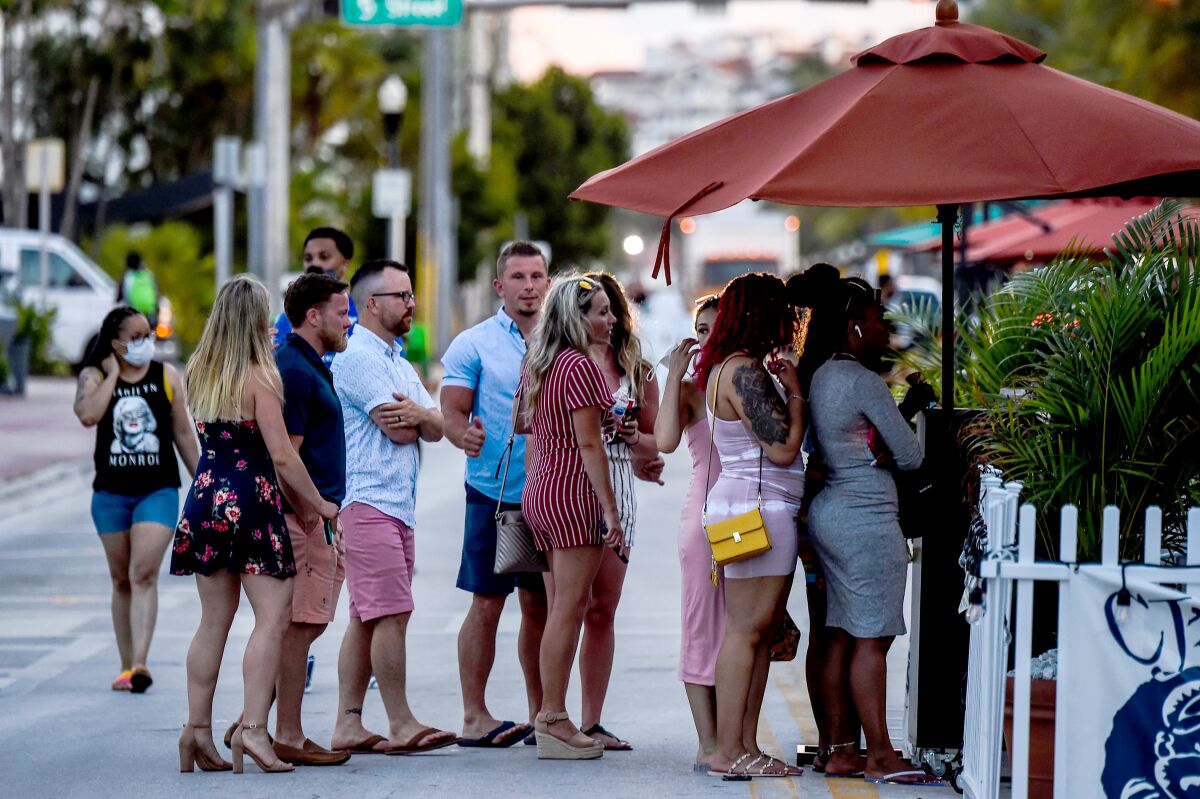 Maskless people line up outside a restaurant in Miami Beach, Fla., in June.