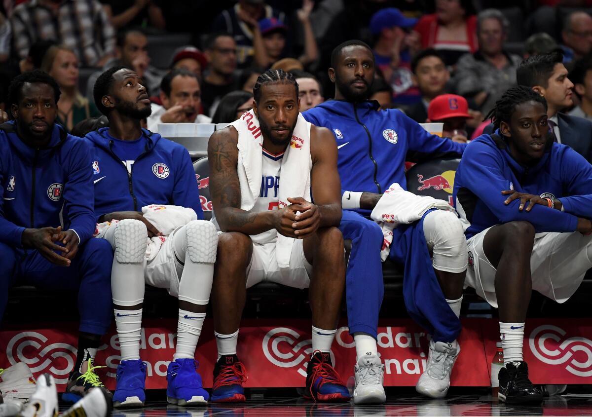 Clippers star Kawhi Leonard sits on the bench.