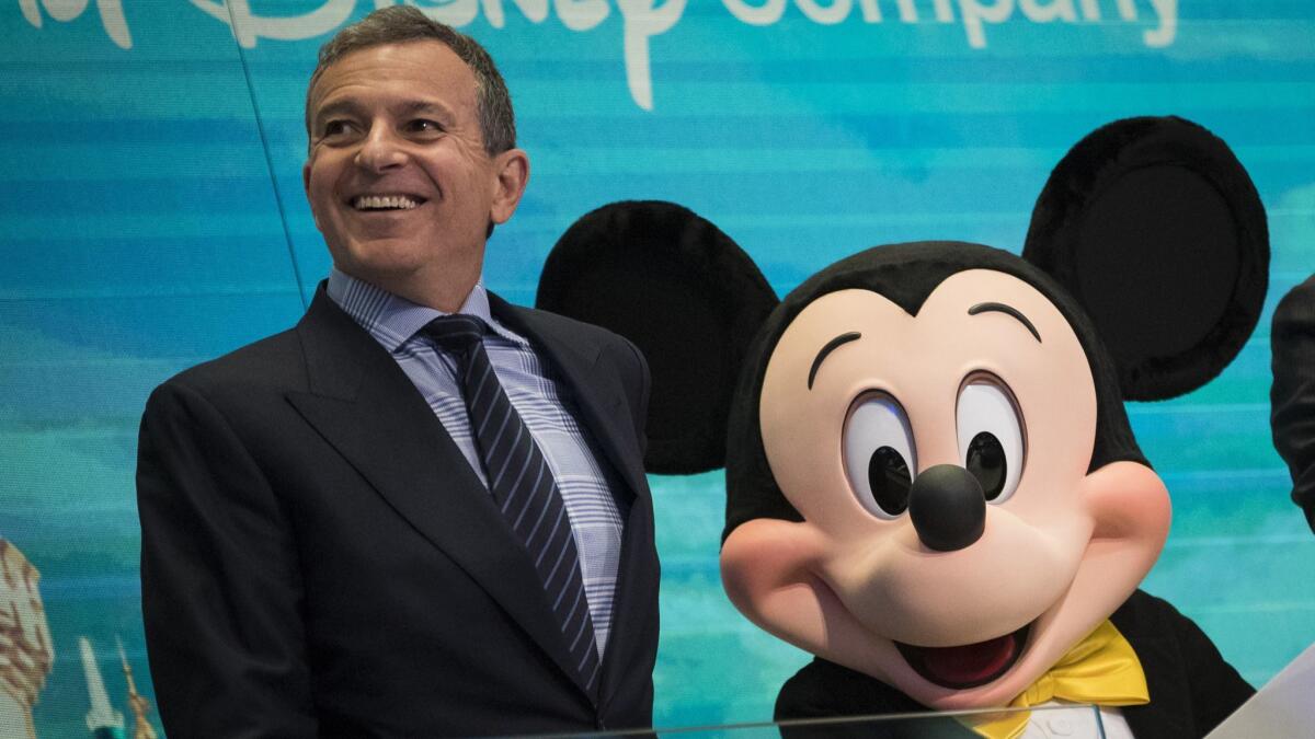 Disney CEO Robert Iger stands next to someone dressed as Mickey Mouse before ringing the opening bell of the New York Stock Exchange on Nov. 27, 2017.