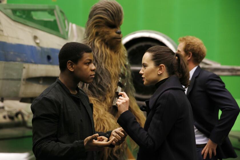 John Boyega and Daisy Ridley speak as Britain's Prince Harry meets with the character Chewbacca during a tour of the Star Wars sets at Pinewood Studios on April 19.