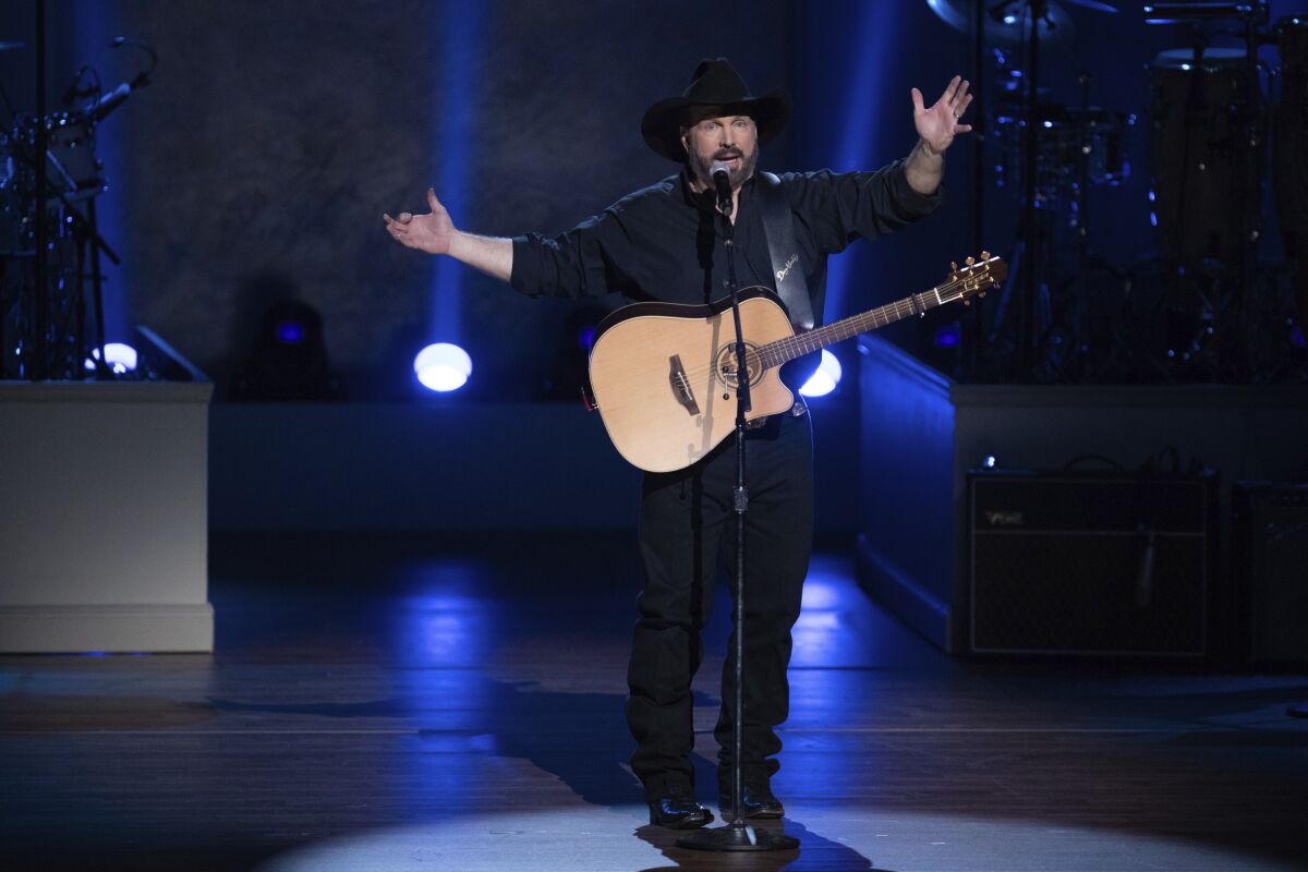FILE - In this March 4, 2020, file photo, country star Garth Brooks performs on stage during the 2020 Gershwin Prize Honoree's Tribute Concert at the DAR Constitution Hall in Washington. Brooks said he will be reassessing whether to continue his stadium tour because of the rising number of COVID-19 cases. In a statement issued on Tuesday, Aug. 3, 2021, Brooks said he is still scheduled to play the next two shows scheduled in Kansas City and Lincoln, Nebraska, but will not put tickets on sale for the next planned stop, Seattle in September. (Photo by Brent N. Clarke/Invision/AP, File)