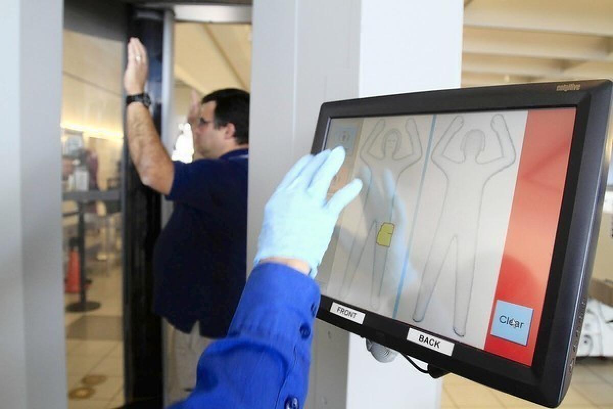 A TSA officer demonstrates the millimeter wave full-body scanners at Ontario airport.