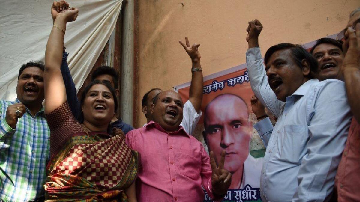 Friends of Kulbhushan Jadhav celebrate outside his childhood home in Mumbai after the alleged Indian spy was given a stay of execution.